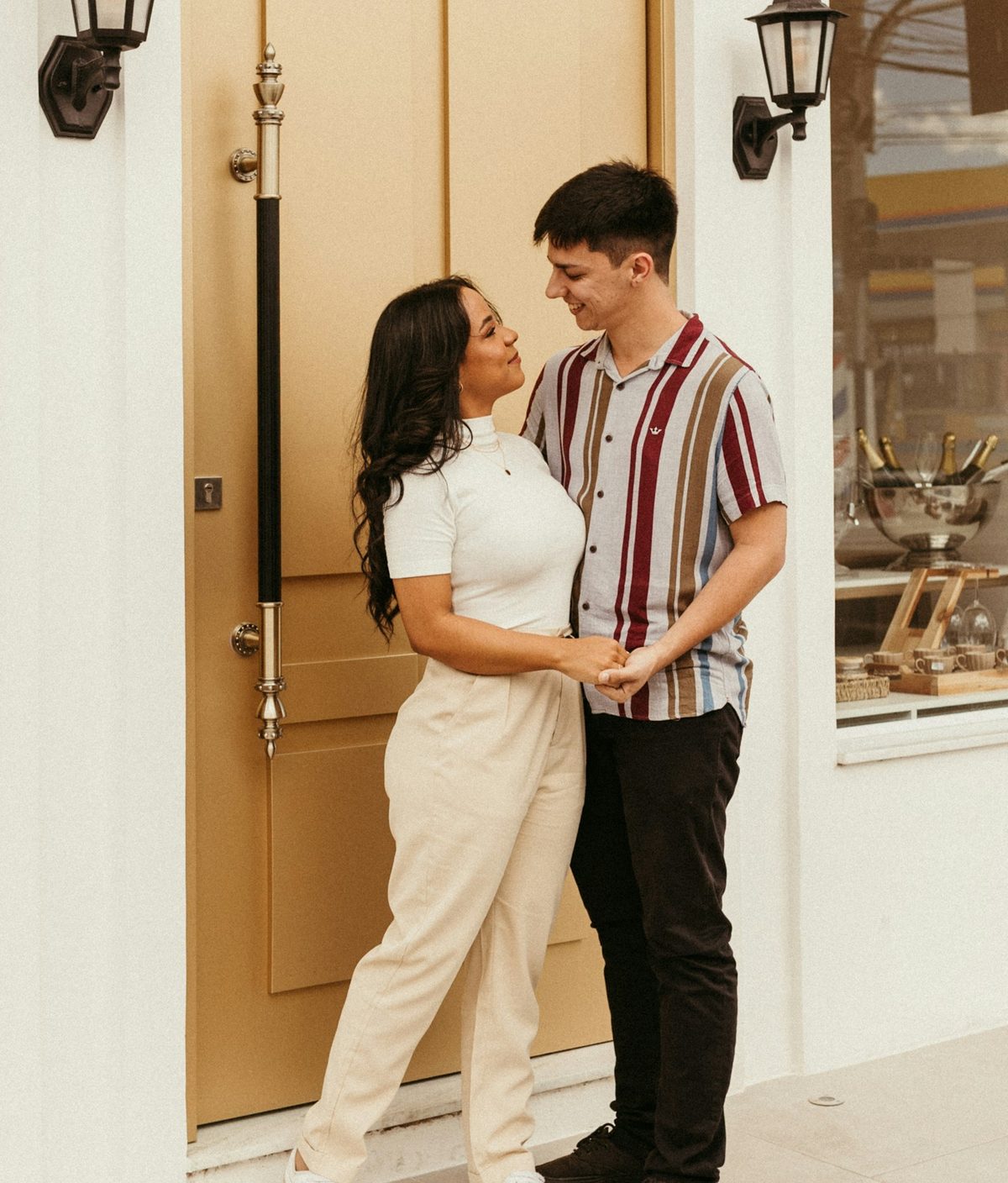 Casal feliz na porta do novo imóvel, simbolizando a conquista da casa própria